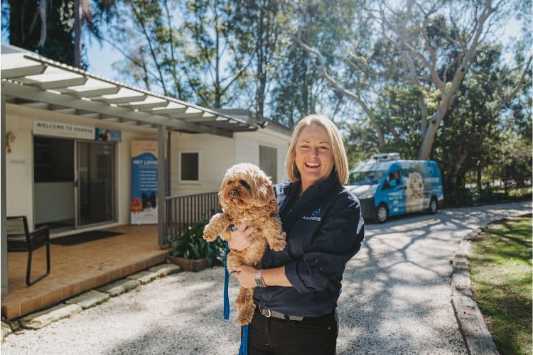 Hanrob Pet Hotels staff holding a small dog outside the office